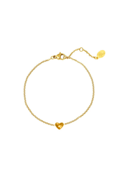 Gold delicate chain bracelet with small heart charm and lobster clasp on white background