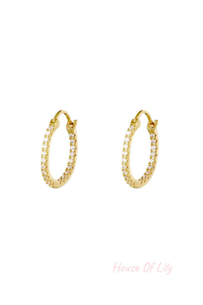 Pair of gold hoop earrings studded with clear stones on white background