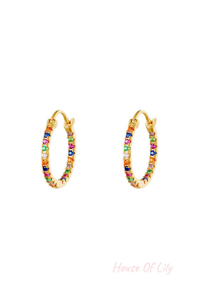 Pair of gold hoop earrings studded with small multicolored stones on white background