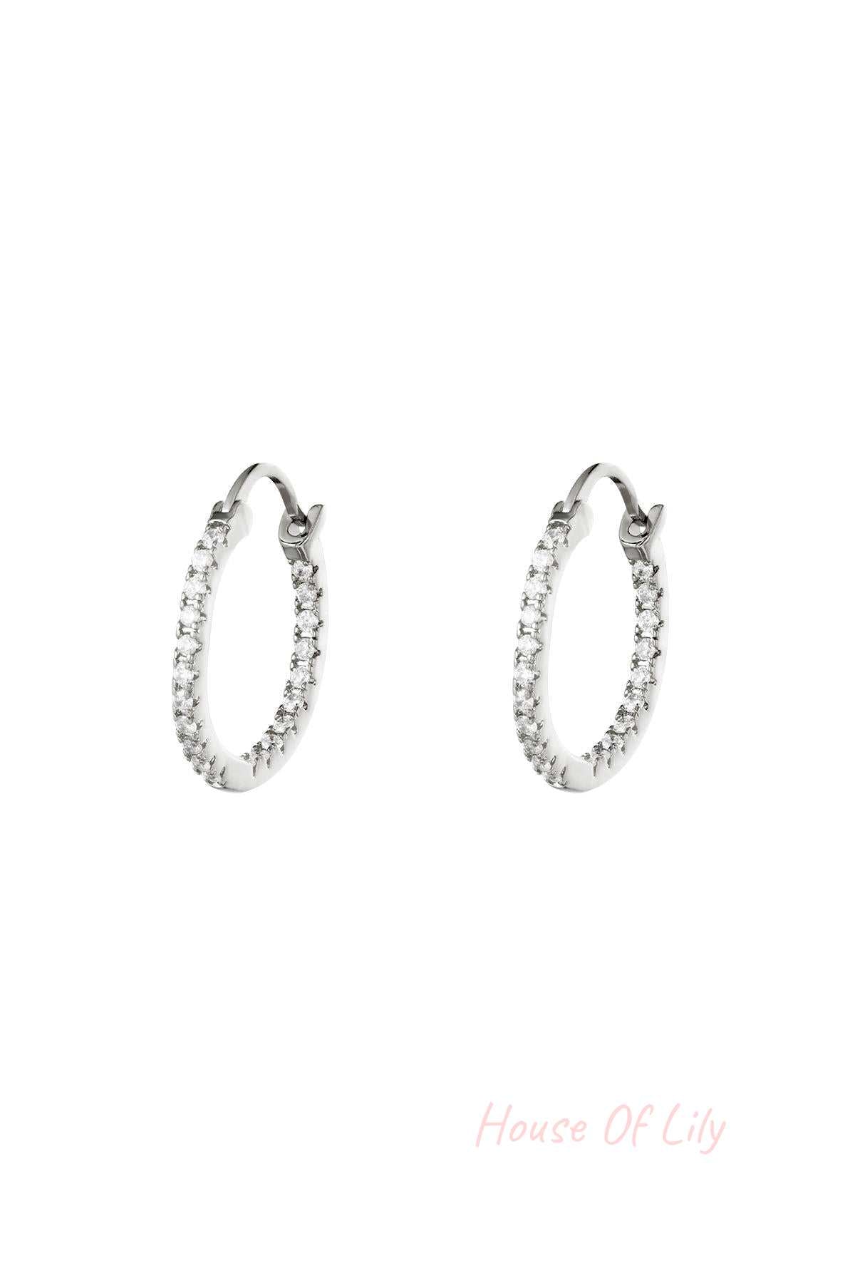 Pair of silver-tone hoop earrings studded with clear stones on white background