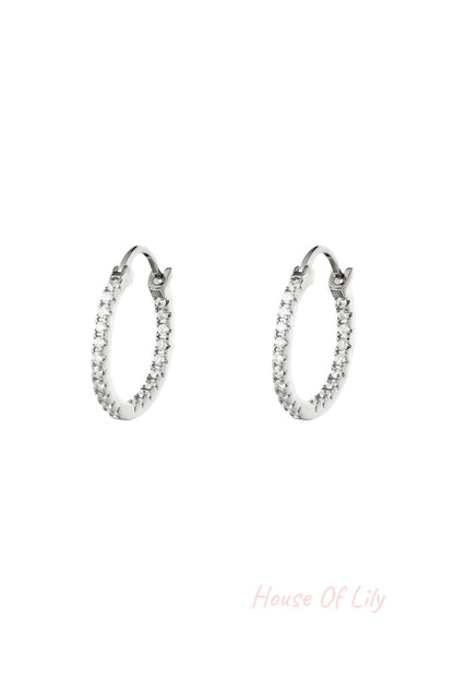 Pair of silver-tone hoop earrings studded with clear stones on white background