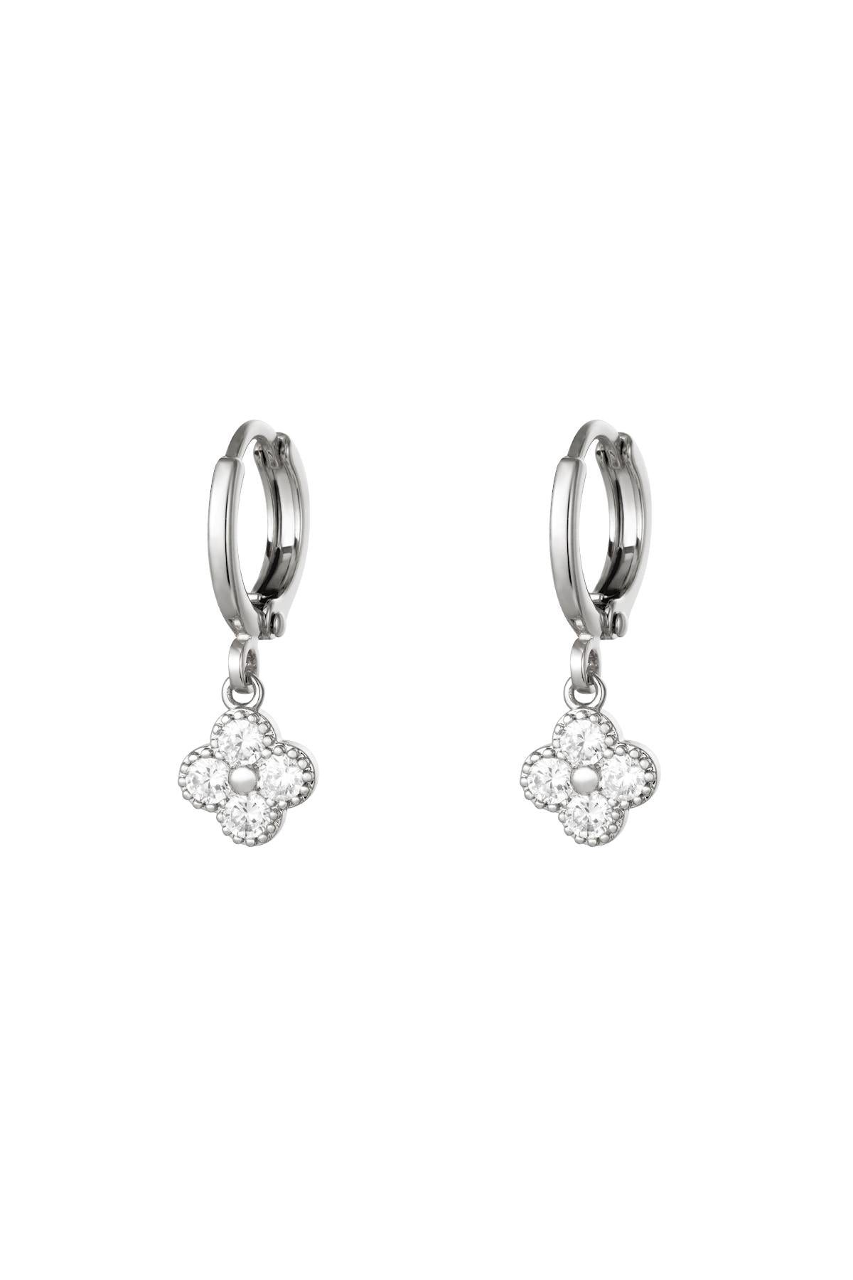 Pair of silver-tone clover drop earrings with clear zircon crystals on a white background