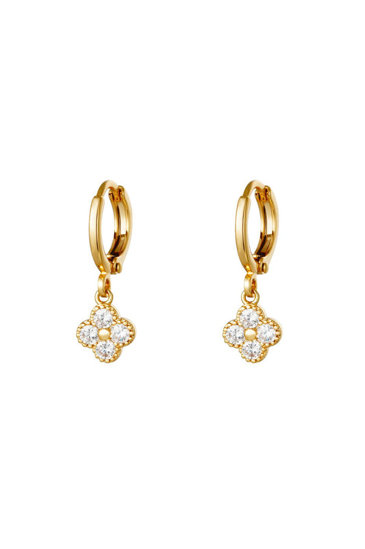 Pair of gold clover drop earrings with clear zircon crystals on a white background