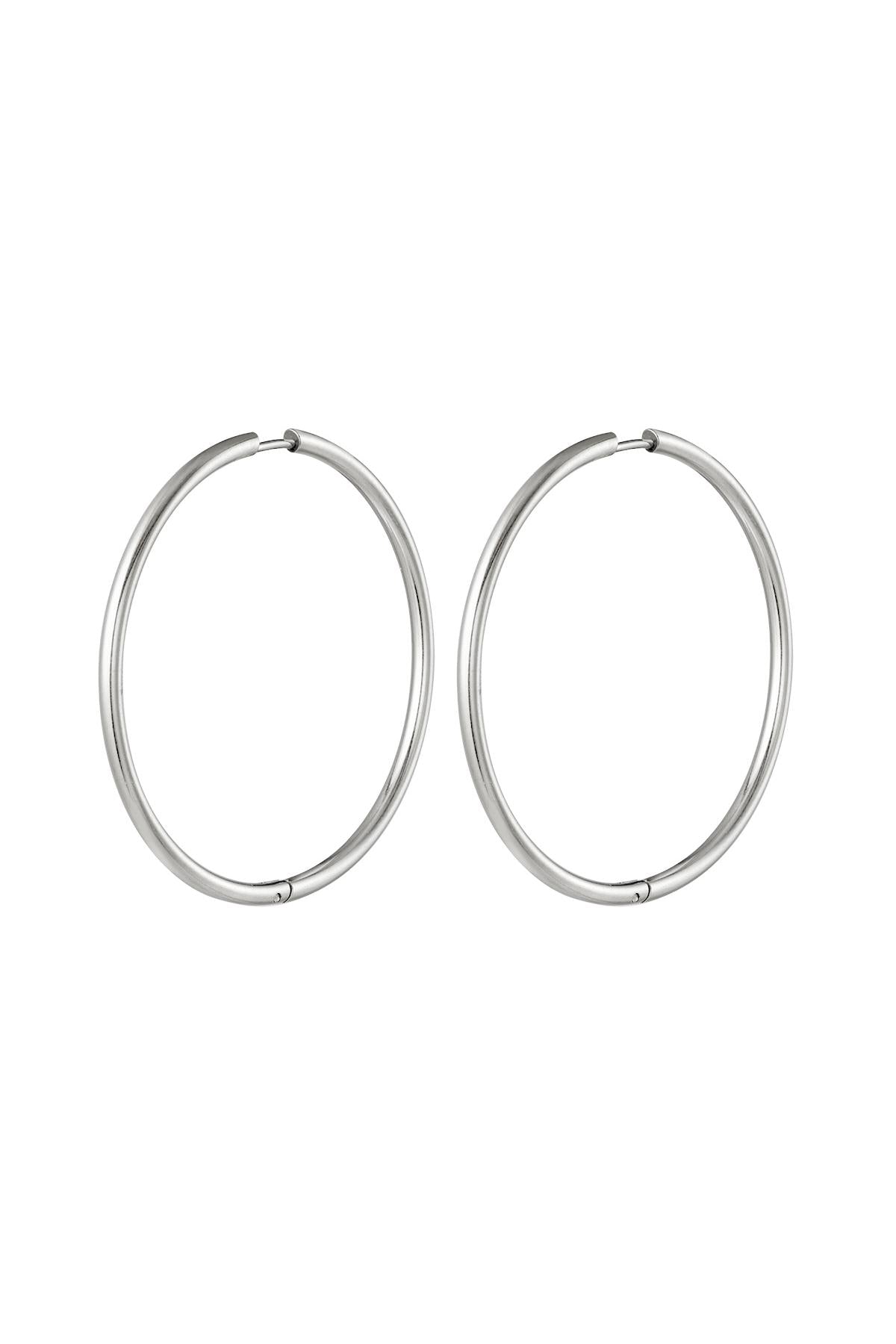Pair of large silver classic minimal hoop earrings isolated on white background