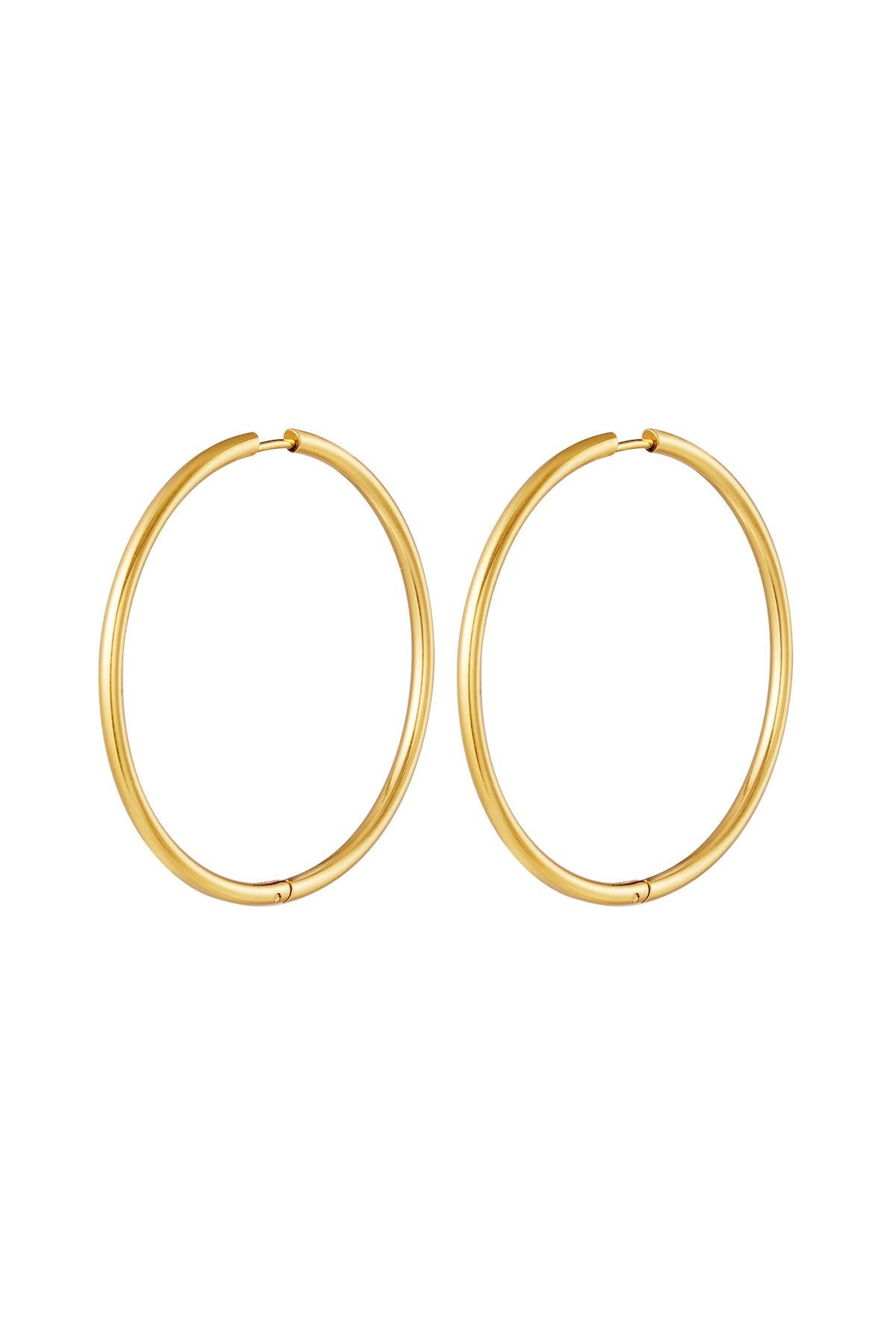Pair of large gold classic minimal hoop earrings isolated on white background