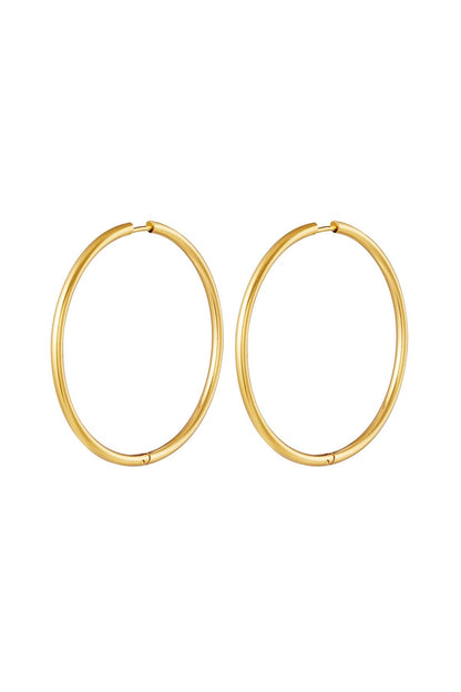Pair of large gold classic minimal hoop earrings isolated on white background