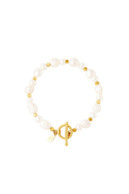Close-up of a pearl beaded bracelet with gold-tone beads and a decorative toggle clasp on a white background
