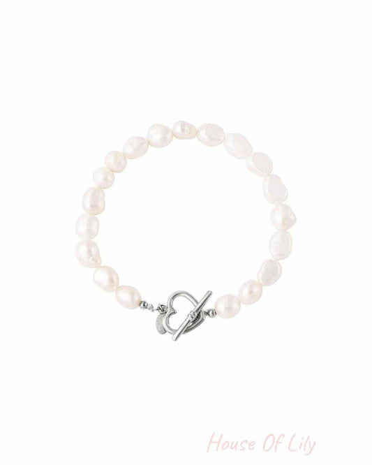 Freshwater pearl bracelet with irregular white pearls and silver heart-shaped toggle clasp on white background, showing variant option.