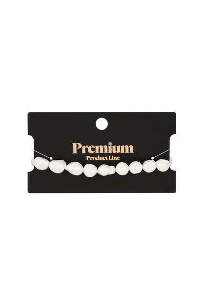 Freshwater pearl bracelet displayed on a black card labeled Premium Product Line, highlighting stocked boutique presentation.