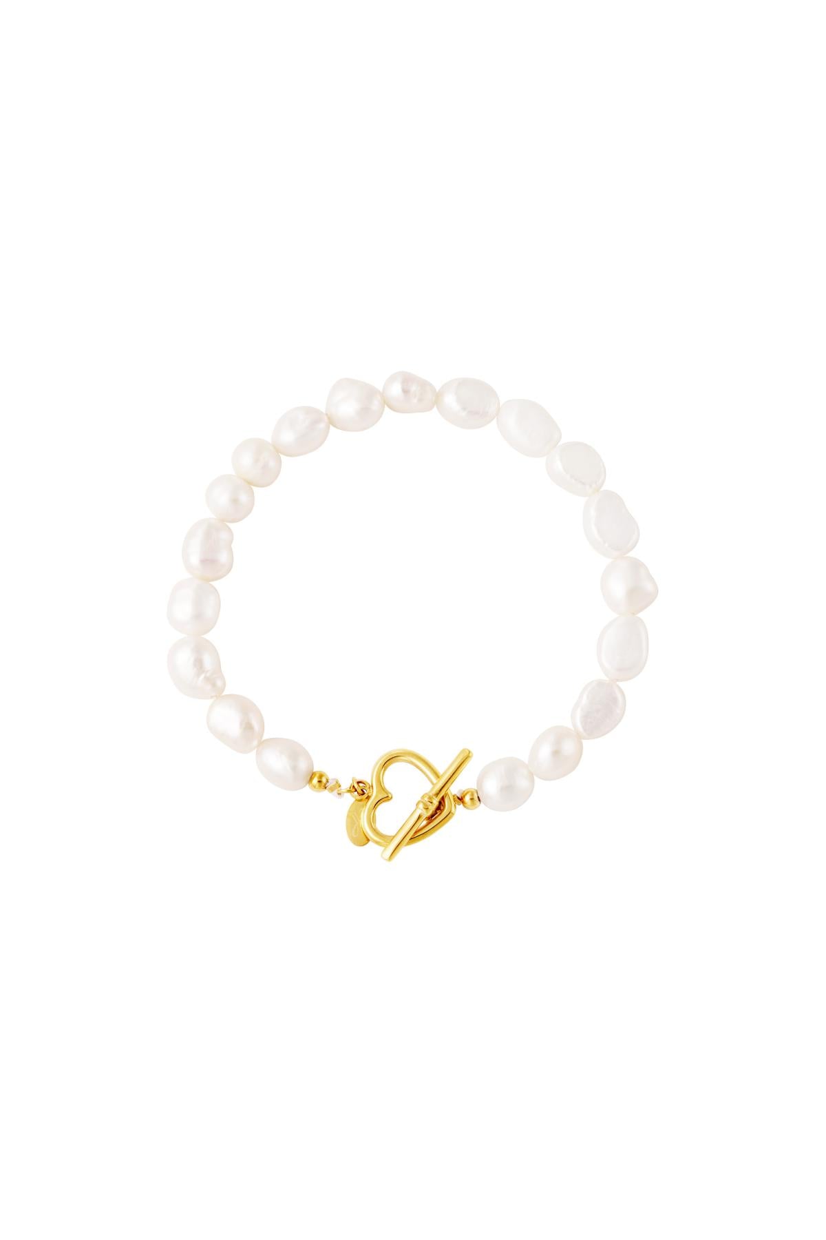 Close-up image of an elegant freshwater pearl bracelet featuring irregular white pearls and a gold heart-shaped toggle clasp on white background.