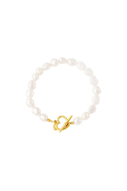 Close-up image of an elegant freshwater pearl bracelet featuring irregular white pearls and a gold heart-shaped toggle clasp on white background.