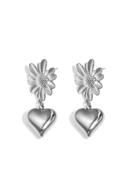 Pair of silver drop earrings with flower tops and hanging heart charms on white background