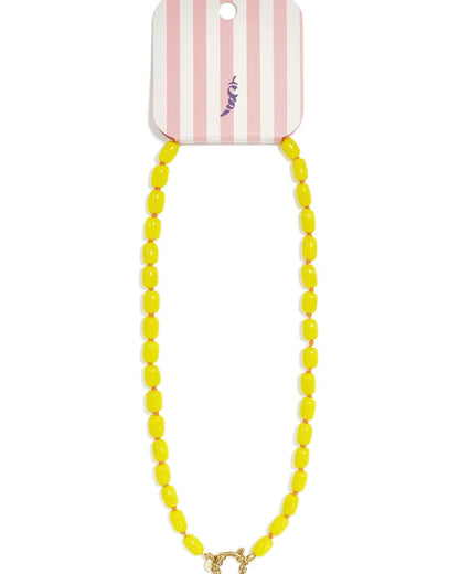 A chunky yellow beaded necklace with a gold clasp on a pink and white striped card.