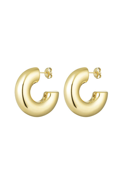 Pair of chunky half-round gold hoop earrings with a polished mirror finish on white background