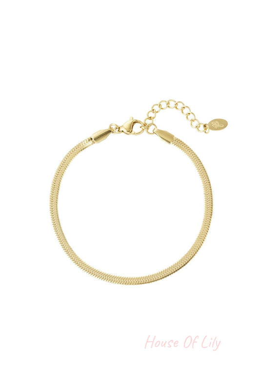 Close-up of a gold-tone herringbone chain bracelet with lobster clasp and adjustable extension chain on a white background