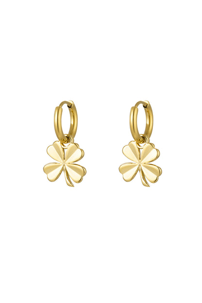 Pair of gold-tone hoop earrings with dangling four-leaf clover charms on white background