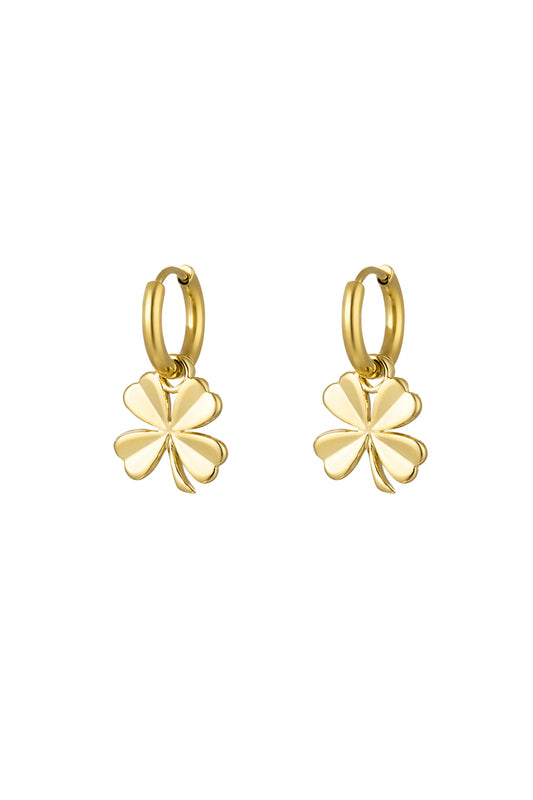 Pair of gold-tone hoop earrings with dangling four-leaf clover charms on white background
