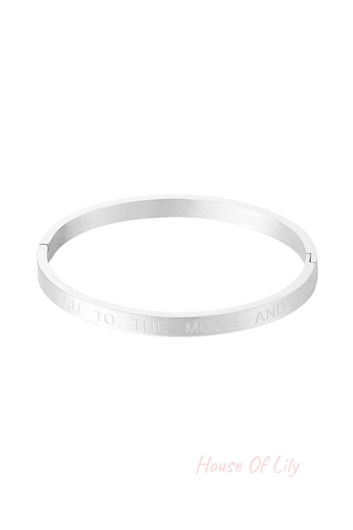 Silver stainless steel bangle bracelet engraved with the phrase 'Love you to the moon and back' on white background