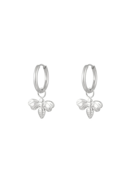 Pair of silver bee charm hoop earrings on white background