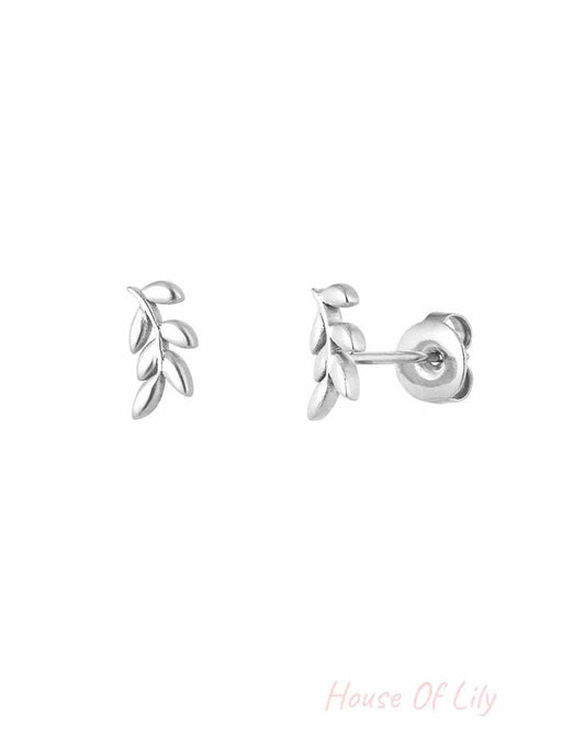 Close-up of silver-tone leaf design stud earrings with push-back closure on white background