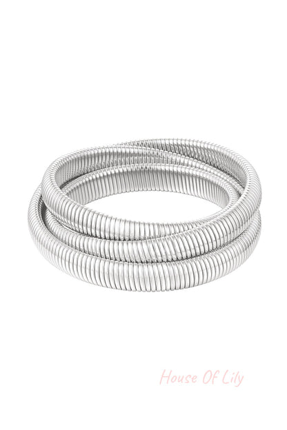 Silver-tone triple coil wrap bracelet with ribbed texture displayed on white background