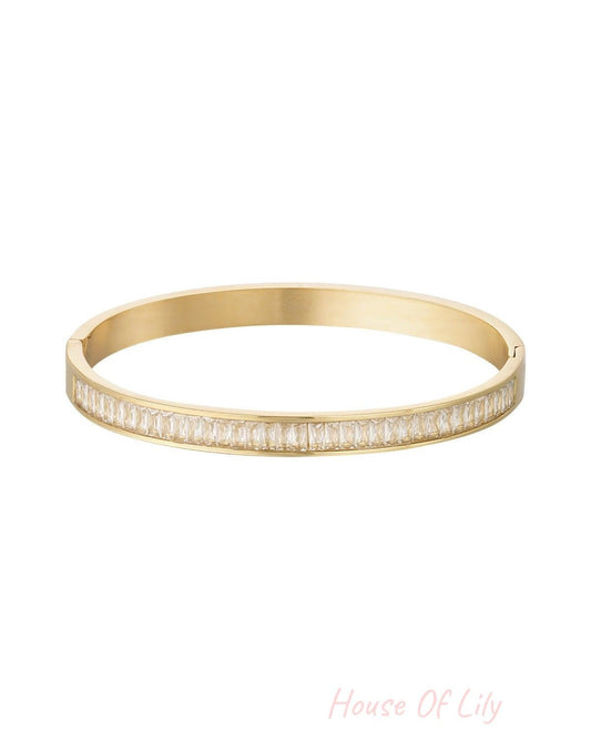 Gold-tone bangle bracelet with sparkling clear square-cut crystal stones displayed on white background