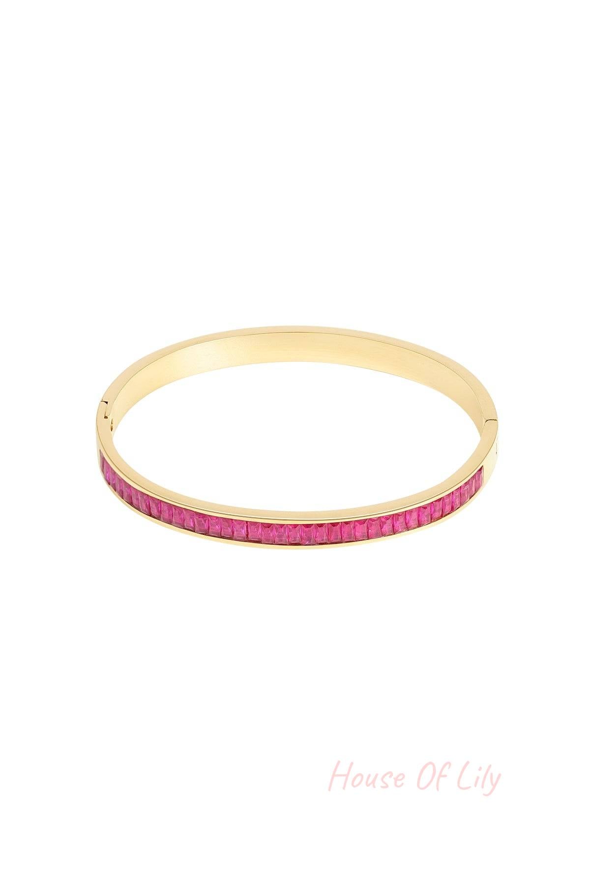 Gold-tone bangle bracelet with vivid pink square-cut crystal stones displayed on white background