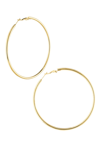Pair of polished gold-colored large hoop earrings with hinged clasp on a white background