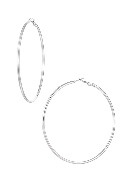 Close-up of large hoop earrings in polished silver color against a white background