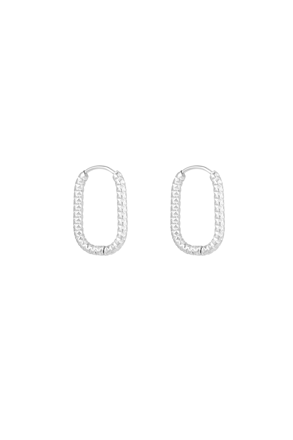 Pair of silver textured oval hoop earrings on white background