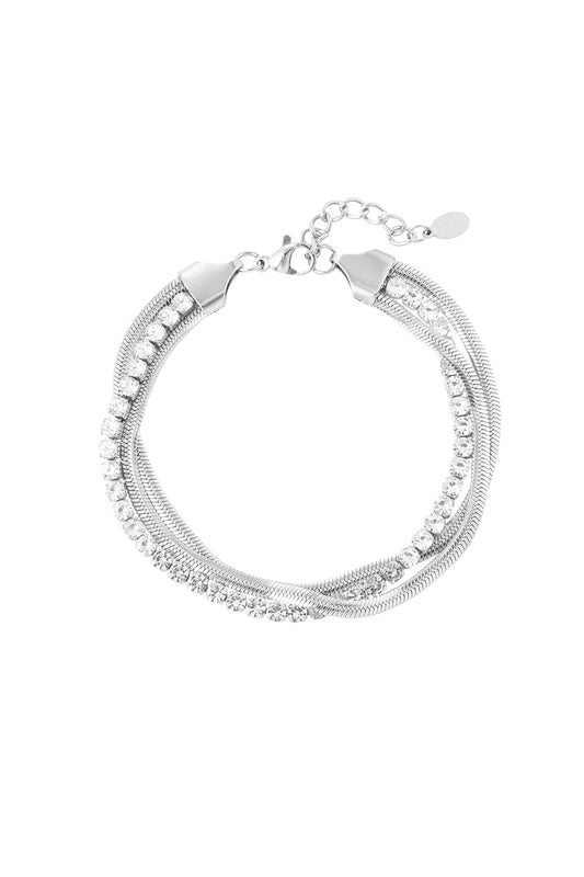 Silver layered chain bracelet with intertwined links and clear rhinestones on white background