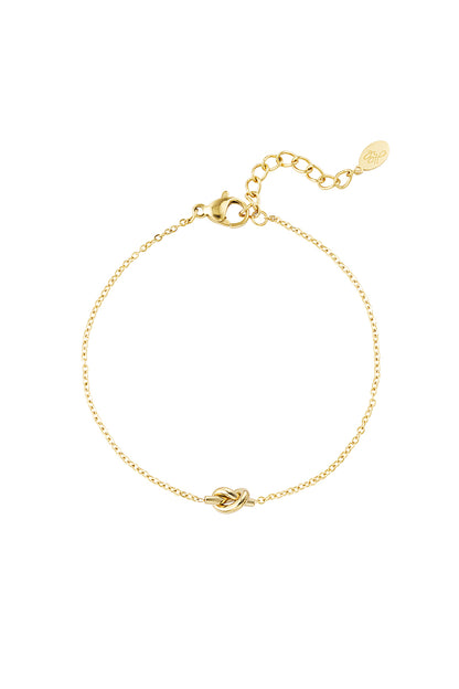 Minimalist delicate gold bracelet with a central knot charm and adjustable chain on a white background