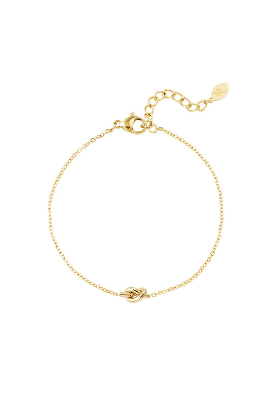 Minimalist delicate gold bracelet with a central knot charm and adjustable chain on a white background