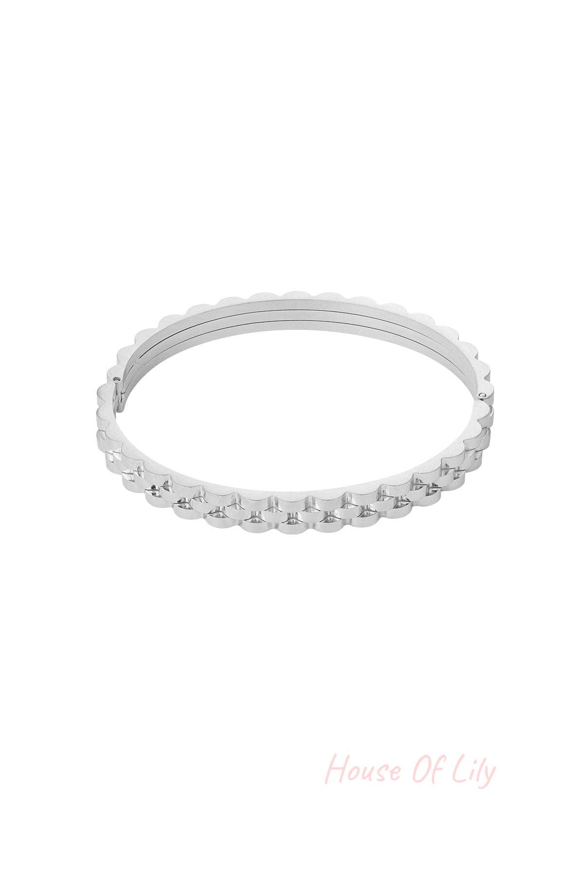 Silver scalloped edge bangle bracelet with a hinged clasp on white background
