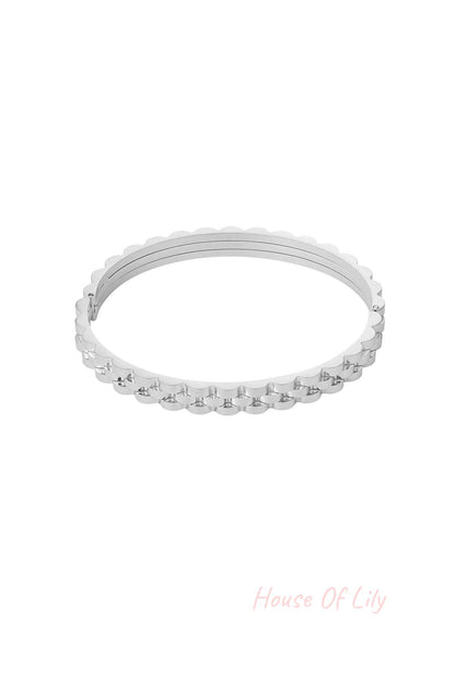 Silver scalloped edge bangle bracelet with a hinged clasp on white background