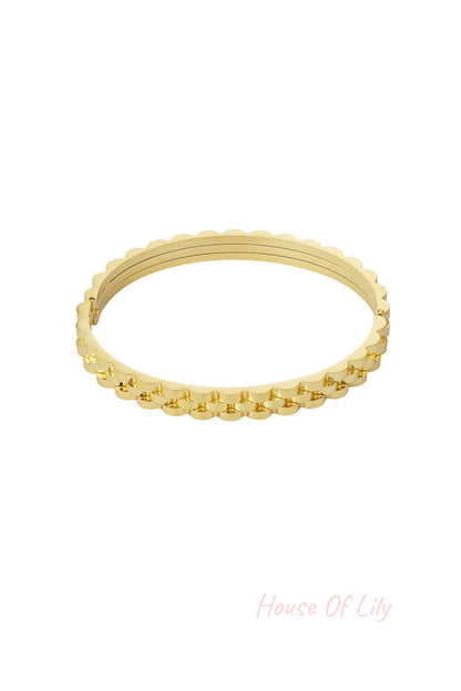 Gold scalloped edge bangle bracelet with hinged clasp on white background