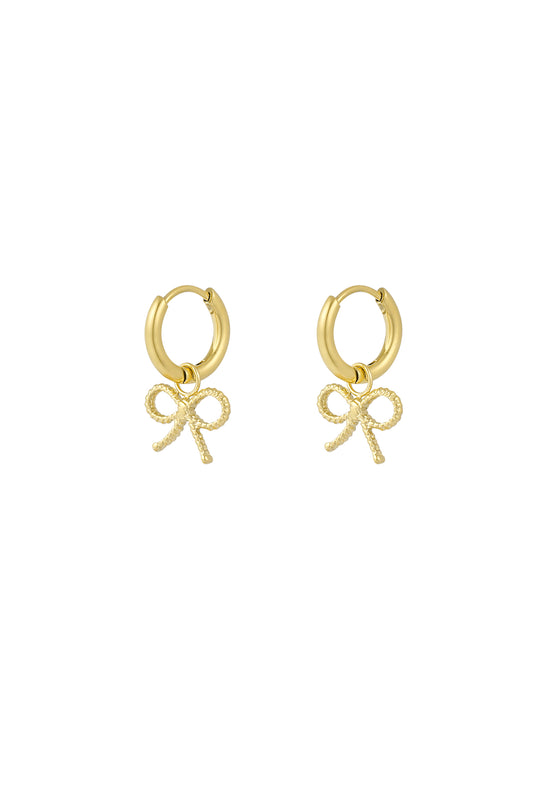 Pair of gold hoop earrings with textured bow charms on white background