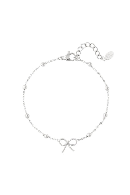 Silver-tone delicate bow charm bracelet with small spherical beads and adjustable chain on white background