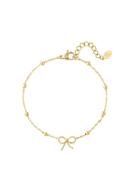 Gold-tone delicate bow charm bracelet with small spherical beads and adjustable chain on white background