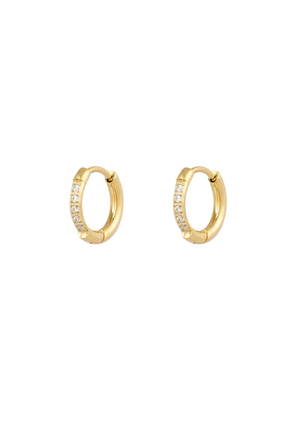 Pair of gold hoop earrings with opal-like white rhinestones on a white background