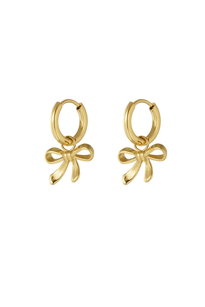 Gold bow charm hoop earrings on white background