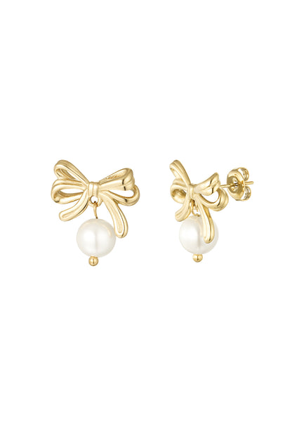 Pair of gold bow earrings with dangling white pearl drops on white background