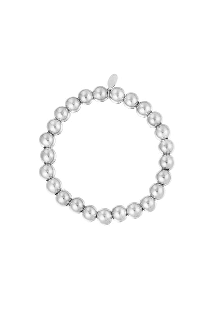 Silver beaded bracelet with polished round beads arranged in a circle with a small tag against white background