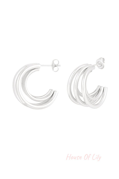 Polished silver tone triple loop hoop earrings isolated on white background showing design detail