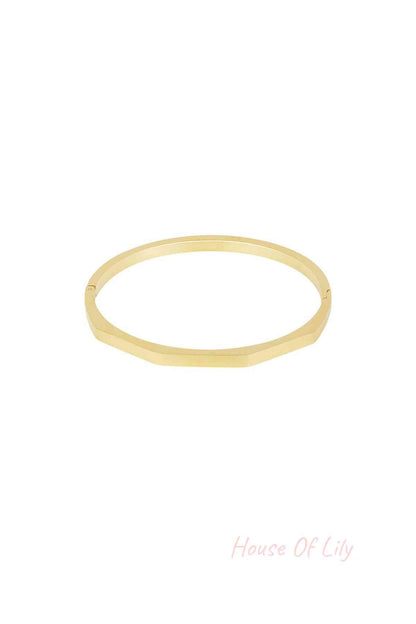 Gold hexagon-shaped bangle bracelet with a smooth matte finish on white background