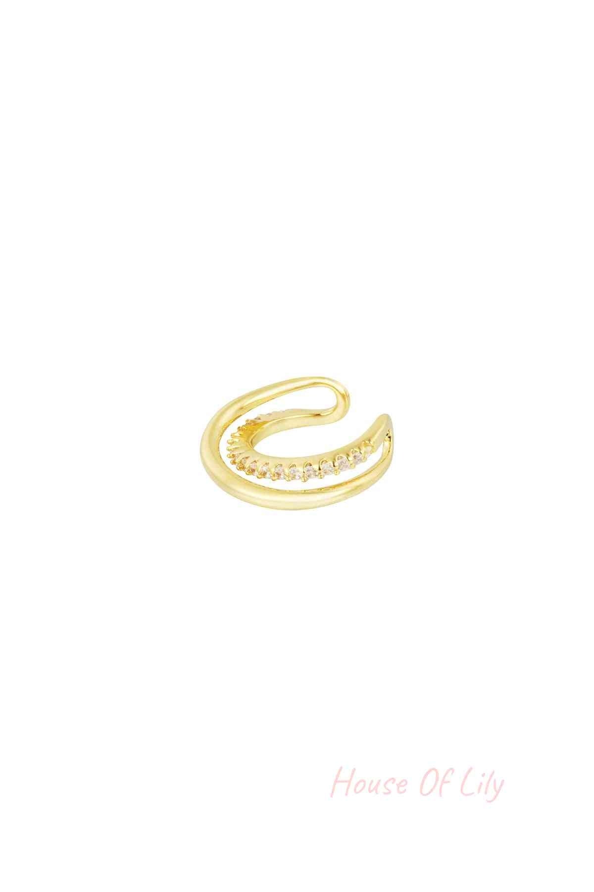 Gold spiral ear cuff with a row of sparkling zirconia stones on a white background