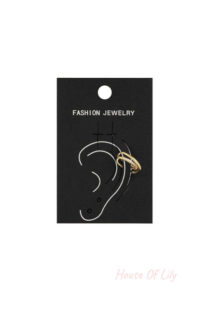 Gold spiral ear cuff attached to a black fashion jewelry card showing ear positioning