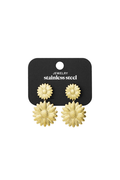 Gold sunflower drop earrings displayed on black stainless steel jewelry card
