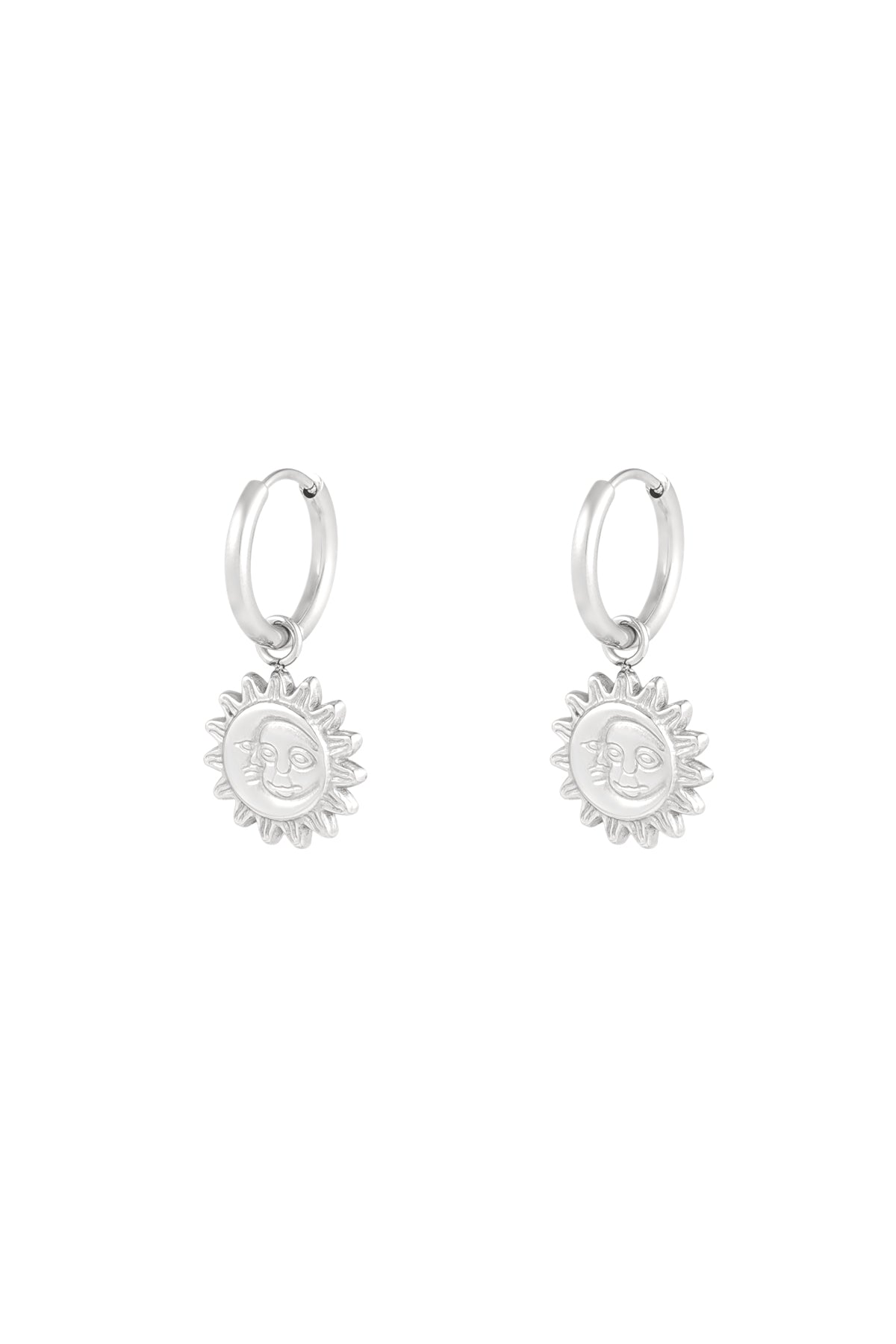 Close-up of silver hoop earrings with sun-shaped dangling charms featuring a smiling face design on white background