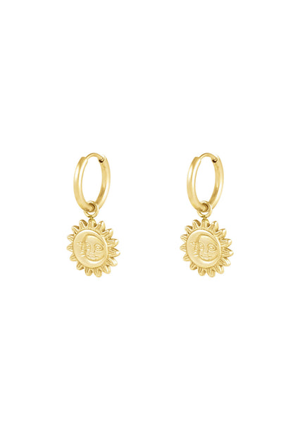 Gold hoop earrings with dangling sun-shaped charms featuring a smiling face design on a white background